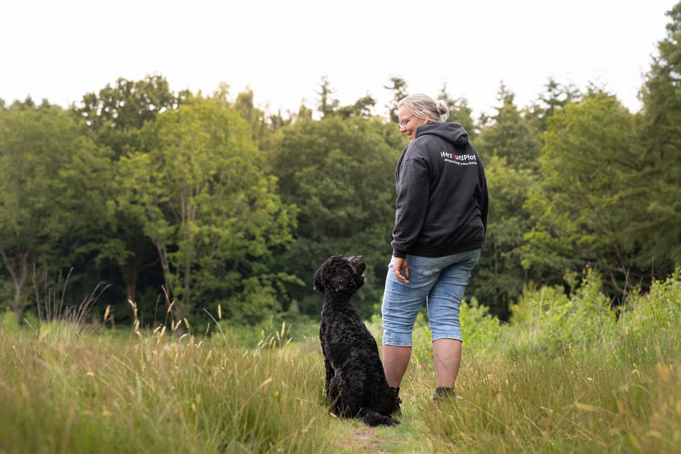 Martina Garske steht mit ihrem Hund Kalle auf einem Feldweg